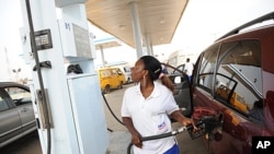 FILE: A fuel attendant fills a tank at a gas station on Lagos' Ibadan highway where new pump prices were implemented. Picture taken Jan. 2, 2012. In June, 2023,. newly inaugurated President Bola Tinubu announced the end to state fuel subsidies, effectively tripling pump prices. 