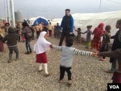 Children demonstrate a game they play in Khazir Camp, Kurdish Iraq on Dec. 1, 2016. (H.Murdock/VOA)