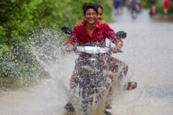 Local people ride a motorbike through a flooded road in Spean Tmor commune, Dangkoa district, Phnom Penh, Cambodia, on Oct. 14, 2020. (Malis Tum/VOA Khmer)