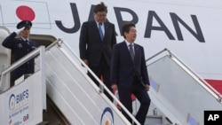 Japanese Prime Minister Shinzo Abe (r) gets down from the plane as he arrives in New Delhi, India, Dec. 11, 2015. Abe is on a three-day visit to India.