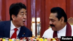 Japan's Prime Minister Shinzo Abe (L) talks with Sri Lankan President Mahinda Rajapaksa during their bilateral meeting at the President Secretariat after in Colombo, September 7, 2014.