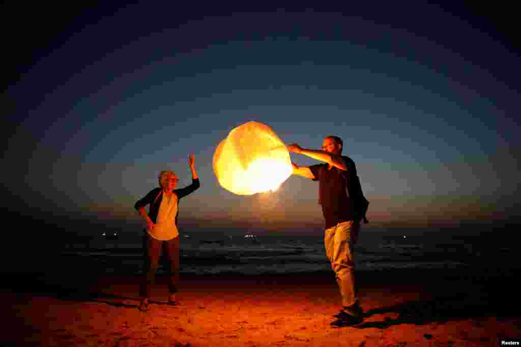 Israeli peace activists release a sky lantern, hoping to illuminate the sky in Gaza, as they protest Israel&#39;s reduction of power supply to Gaza at a beach in Ashkelon, southern Israel.