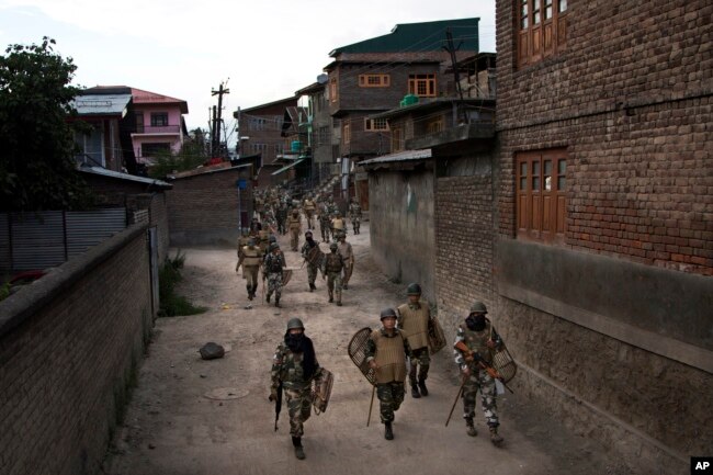 In this Aug. 18, 2016 file photo, Indian paramilitary soldiers walk back towards their base camp after a day long curfew in Srinagar, Indian controlled Kashmir.