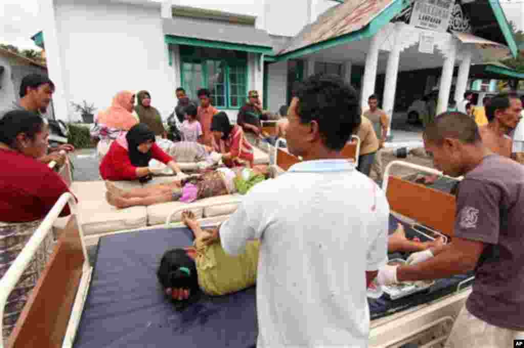 Para warga yang terluka mendapat perawatan di luar puskesmas kabupaten Bener Meriah, Aceh (2/7). (AP/Ahmad Ariska)