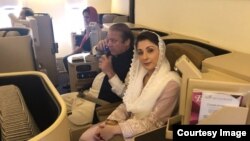 Ousted Pakistani Prime Minister Nawaz Sharif and his daughter, Maryam, sit on a Lahore-bound flight due for departure, at Abu Dhabi International Airport, UAE, July 13, 2018. 