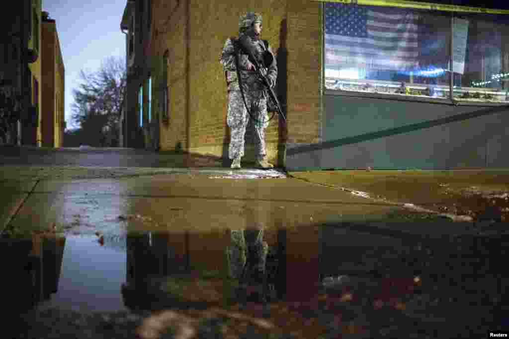 A National Guard soldier stands guard outside of the Ferguson City Hall during a third night of protests following the grand jury verdict in the Michael Brown shooting in Ferguson, Missouri, Nov. 26, 2014. 