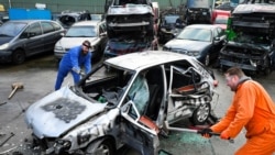 Twin brothers Steven and Brian Krijger use hammers to scrap a car to express their frustration as the Netherlands undergoes another lockdown in Vijfhuizen, Netherlands January 5, 2022. Picture taken January 5, 2022. (REUTERS/Piroschka van de Wouw)