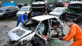 Twin brothers Steven and Brian Krijger use hammers to scrap a car to express their frustration as the Netherlands undergoes another lockdown in Vijfhuizen, Netherlands January 5, 2022. Picture taken January 5, 2022. (REUTERS/Piroschka van de Wouw)