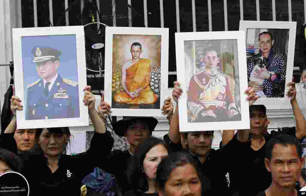 Thai mourners hold up portraits of the late King Bhumibol Adulyadej near Grand Palace to take part in the Royal Cremation ceremony in Bangkok, Thailand, Wednesday, Oct. 25, 2017. 