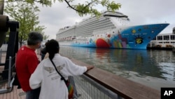 FILE - People pause look at cruise ship Norwegian Breakaway, on the Hudson River, in New York City, May 8, 2013. Ten people aboard the cruise ship, which docked Sunday in New Orleans, have tested positive for COVID-19, officials said. 