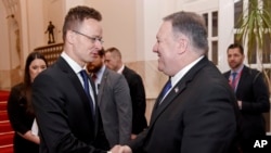 U.S. Secretary of State, Mike Pompeo, right, and Hungary's Minister of Foreign Affairs and Trade, Peter Szijjarto, left, shake hands in Budapest, Hungary, Feb. 11, 2019.