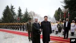 Chinese President Xi Jinping, center right, shakes hands with Iranian President Hassan Rouhani, as they pose for a photograph in an official arrival ceremony, at the Saadabad Palace in Tehran, Iran, Jan. 23, 2016. 
