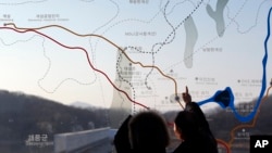 지난 1월 한국 파주시 판문점 인근 임진각에서 관광객들이 남북 한계선을 그려놓은 한반도 지도를 바라보고 있다.