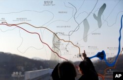 FILE - People look at a map of the border area between North and South Koreas at the Imjingak Pavilion near the border village of Panmunjom, which has separated the two Koreas since the Korean War, in Paju, north of Seoul, South Korea, Jan. 11, 2016.