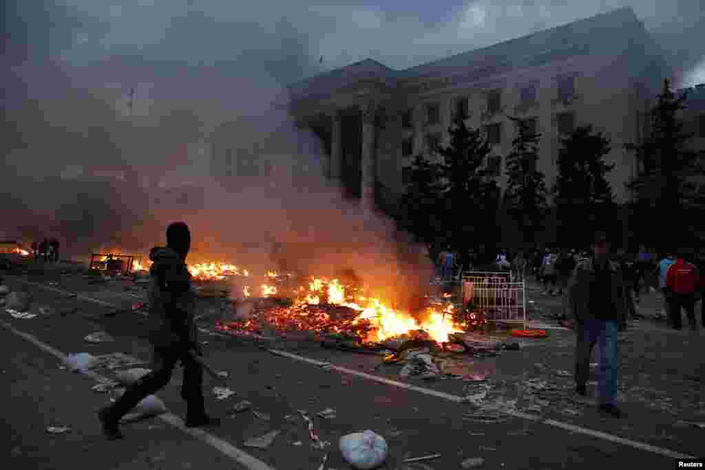 A protester walks past a burning pro-Russian tent camp near the trade union building in Odessa, Ukraine, May 2, 2014. 