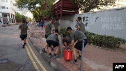 中国驻港部队军人星期六（11月16日）在香港清除抗议活动之后留下的路障和垃圾。