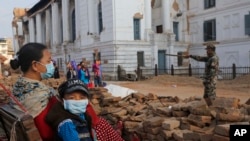 네팔 어머니와 아들이 1일 카트만두에서 지진으로 무너진 잔해를 보고 있다.