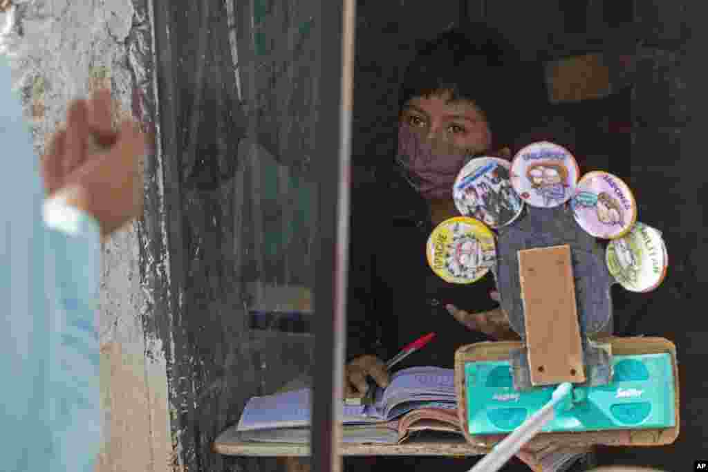 Eleven-year-old Oscar Rojas listens to his teacher Gerardo Ixcoy, outside Oscar&#39;s home in Santa Cruz del Quiche, Guatemala.