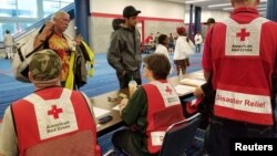 Evacuees arrive to seek shelter with Red Cross volunteers at the George Brown convention center after flood waters of Hurricane Harvey forced them to leave their homes in Houston, Texas, Aug. 27, 2017. 