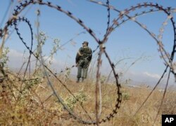 A Syrian army soldier stands guard near the village of Tal Kroum, Syria, Aug. 14, 2018. The Russian military said Tuesday that its forces in Syria will help U.N. peacekeepers fully restore patrols along the frontier with the Israeli-occupied Golan Heights.