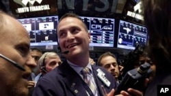 FILE - Trader Jonathan Corpina, center, smiles as he works on the floor of the New York Stock Exchange, June 21, 2013.