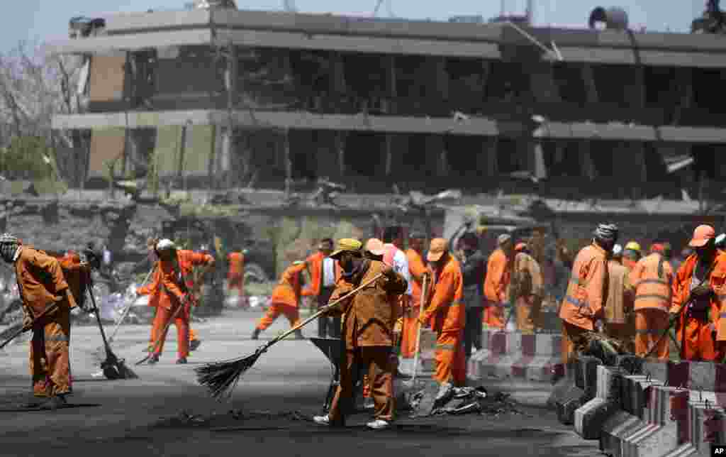 Afghan Municipality workers sweep a road in front of the German Embassy after a suicide attack in Kabul, Afghanistan, May 31, 2017.