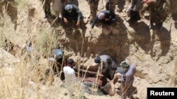Villagers collect the dead bodies of civilians who were killed by insurgents at Mirza Olang village, in Sar-e Pul province, Afghanistan, Aug. 15, 2017.