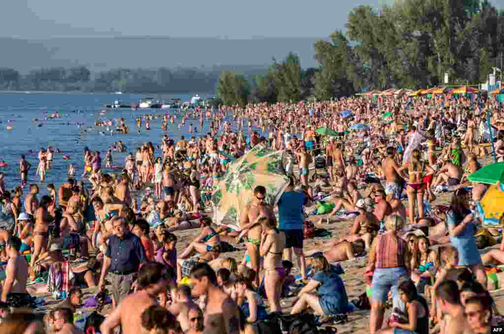 People sunbathe at a beach on the Volga river in downtown Samara, Russia.