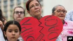 Angela Reyes holds a sign while participating in a vigil at the Governor's Mansion in Austin, Texas, Thursday, in response to the Supreme Court decision about President Obama’s immigration executive order. (Jay Janner/Austin American-Statesman via AP)