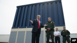 En esta foto de archivo del 13 de marzo de 2018, el presidente Donald Trump habla con los reporteros mientras revisa los prototipos del muro fronterizo en San Diego.