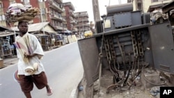 A man walks past a broken electricity transformer in Lagos, Nigeria. Corruption and mismanagement leave Africa's oil giant chronically short of electricity. 