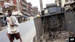 FILE - A man walks past a broken electricity transformer in Lagos, Nigeria.