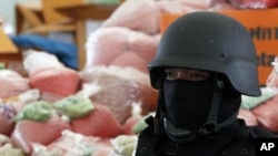 ຕໍາຫລວດໄທຢືນຍາມຖົງຢາບ້າ methamphetamine ທີ່ຍຶດມາໄດ້ ທີ່ຈັງຫວັດອະຍຸດທະຍາ ຂອງໄທ, ວັນທີ 24 ມີຖຸນາ 2011. REUTERS/Sukree Sukplang (THAILAND - Tags: CRIME LAW SOCIETY)