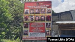 Baliho Daftar Pencarian Orang (DPO) Polisi yang memuat nama dan foto anggota kelompok Mujahidin Indonesia Timur (MIT) yang terpajang di Desa Tongoa, Kecamatan Palolo, Kabupaten Sigi, Sulawesi Tengah, Sabtu, 12 Desember 2020. (Foto: Yoanes Litha/VOA)