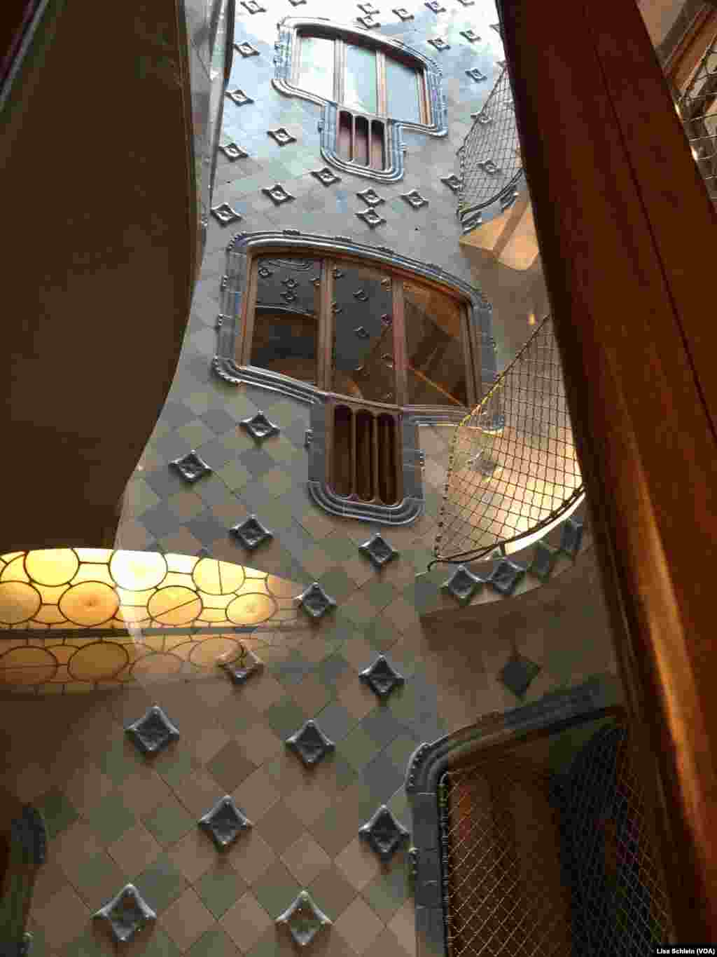 A huge central skylight illuminates the dark blue tiles on the upper floors of Casa Batllo, in Barcelona.