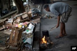 William, who is homeless, prepares lunch at a park in Rio de Janeiro, Brazil, Dec. 8, 2017.