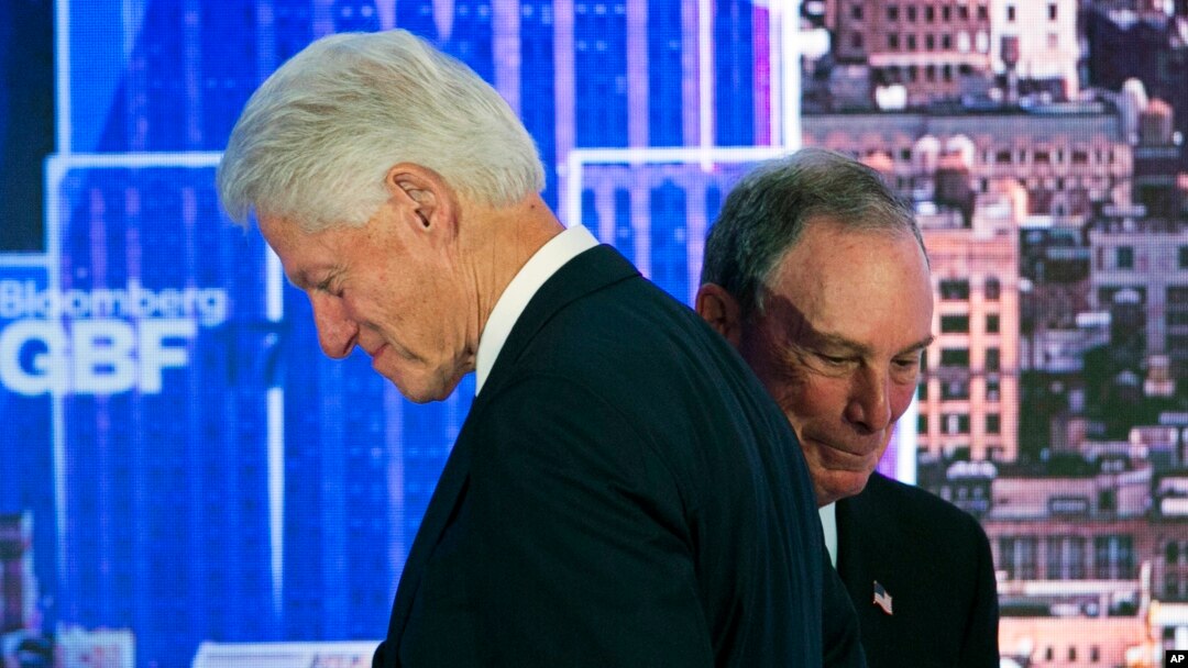 Former U.S. President Bill Clinton, left, passes former New York Mayor Michael Bloomberg after he was introduced as a speaker at the Bloomberg Global Business Forum, Sept. 20, 2017, in New York.