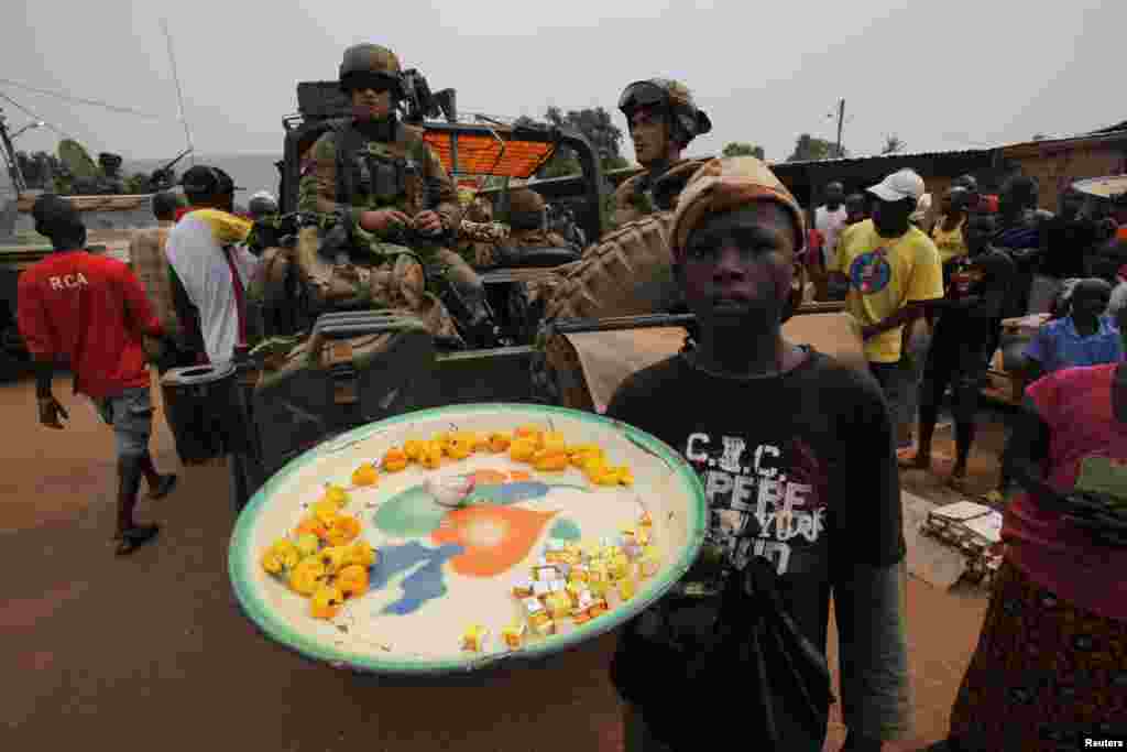 A street vendor stands near French soldiers in patrol in the pro-Christian area of Bangui, Feb. 15, 2014. 