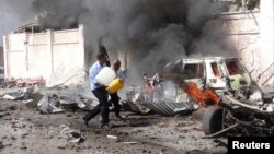 Somalijski pripadnici obezbeđenja pokušavaju da ugase vatru posle eksplozije u Mogadišu, 3. decembar 2014. 