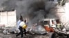 ماموران در حال خاموش کردن آتش خودروی انفجاری در برابر فرودگاه موگادیشو . ۳ دسامبر ۲۰۱۴