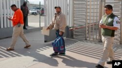 온두라스 출신 이주자(가운데)가 29일 망명신청절차가 진행되는 동안 미국에 머무를 수 없다는 새 규정에 따라 멕시코 티후아나로 송환되고 있다. 