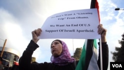 A Palestinian women hold up a sign march 19, protesting the West Bank visit of President Barack Obama. Photo: VOA / R. Collard