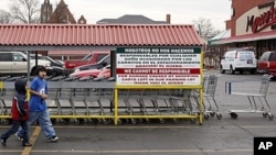 Hispanic children walk through a parking lot after returning a shopping cart at one of the Mexican grocery stores in Aurora, Illinois, March 29, 2011. More than 35,000 of about 55,000 new residents in Aurora between 2000 to 2010 were Hispanic.