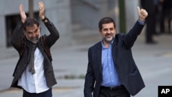 Jordi Cuixart, president of the Catalan Omnium Cultural organization, left, and Jordi Sanchez, president of the Catalan National Assembly, wave to supporters on arrival at the national court in Madrid, Spain, Oct. 16, 2017.