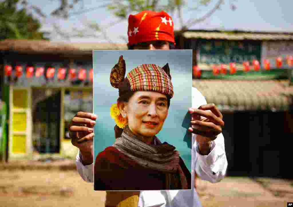 A supporter holds up a portrait of Aung San Suu Kyi during an election campaign of the National League for Democracy party in Rangoon, March 28, 2012. (Reuters)