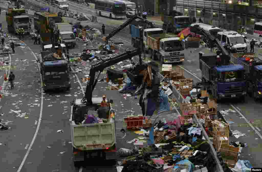 Uma área que tinha sido bloqueada pelos apoiantes do movimento pró-democracia está a ser agora limpa. Sede do Governo em Hong Kong, Dez. 11, 2014.