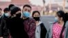 Residentes de Beijing con máscaras para protegerse del nuevo coronavirus cerca de la Plaza de Tiananmen de Beijing el 22 de enero de 2020.