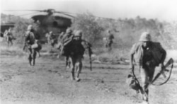 Back in action, U.S. Marines run from CH-53 helicopter that landed them on Koh Tang island 30 miles off Cambodia in the rescue of U.S. merchant ship SS Mayaguez, May 15, 1975. (AP Photo)