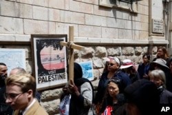 Fieles cristianos caminan por la Via Dolorosa hacia la Iglesia del Santo Sepulcro en Jerusalén el Viernes Santo, 19 de abril de 2019.