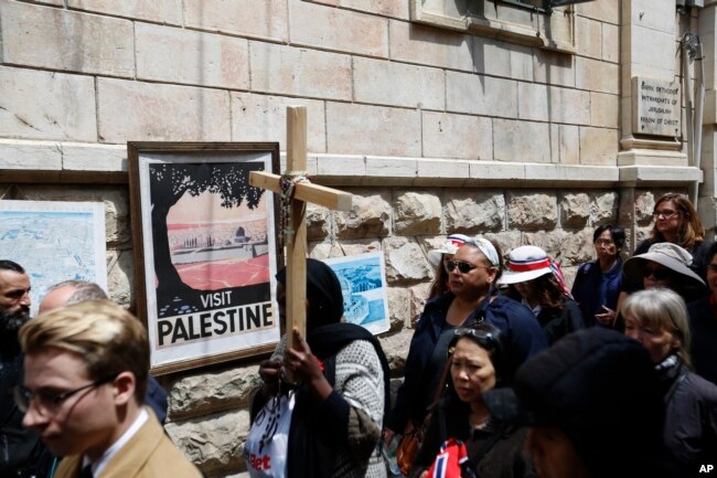 Fieles cristianos caminan por la Via Dolorosa hacia la Iglesia del Santo Sepulcro en Jerusalén el Viernes Santo, 19 de abril de 2019.